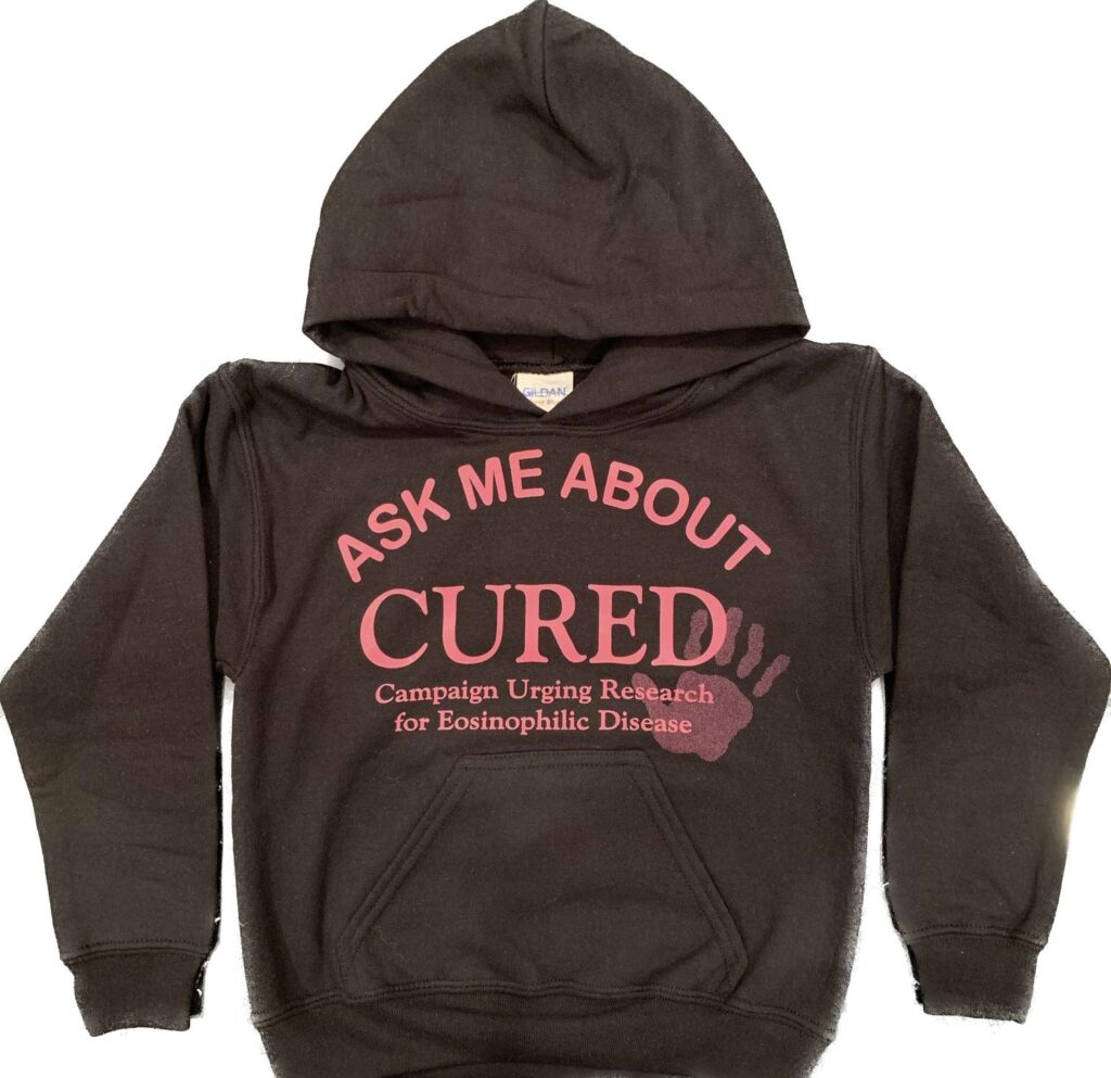 Black hoodie with "Ask Me About CURED" text.