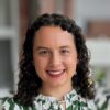 Smiling woman with curly hair, green blouse